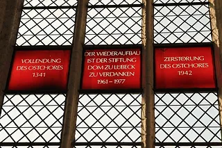 Symbolbild zur Unterseite für Besucher: zeigt Glasfenster, das an den Wiederaufbau des Ostchores erinnert